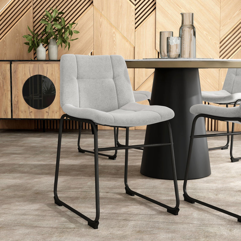 Angled set of two contemporary light grey chenille dining side chairs with black bases in a room with accessories