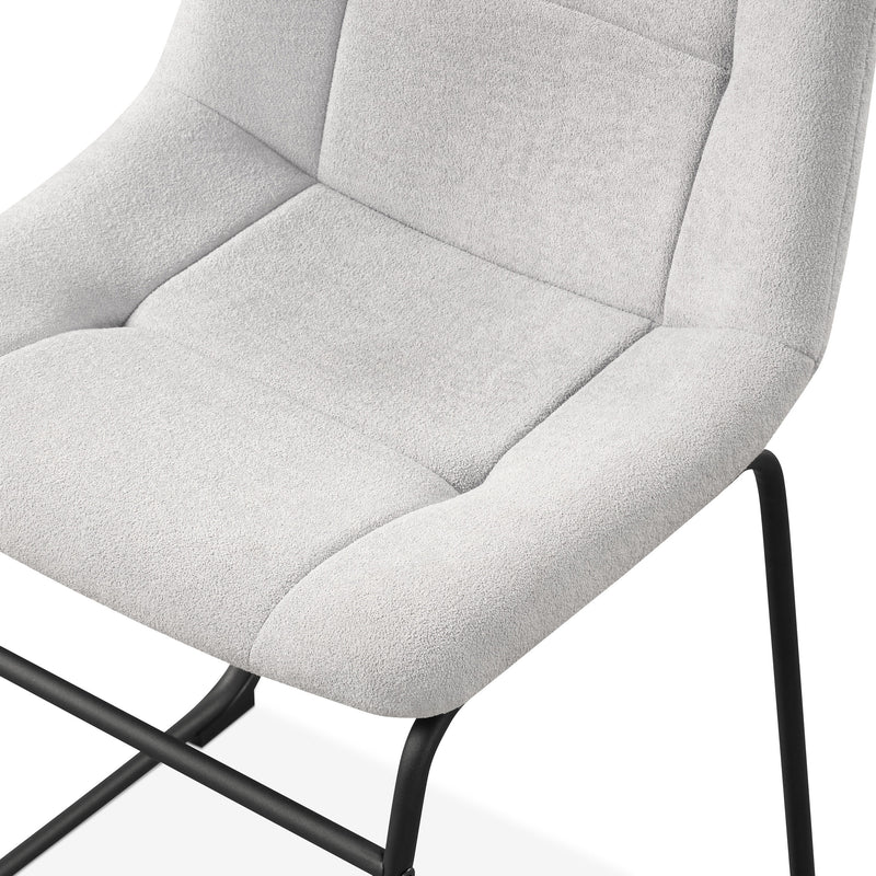 Left facing close up single view of the seat on a set of two contemporary light grey chenille dining side chairs with black bases on a white background