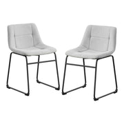 Angled set of two contemporary light grey chenille dining side chairs with black bases on a white background