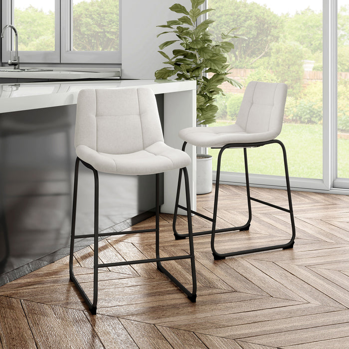 Angled set of two contemporary white chenille counter height stools with black bases in a room with accessories