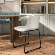 Left facing single view of a set of two contemporary white chenille dining side chairs with black bases in a room with accessories