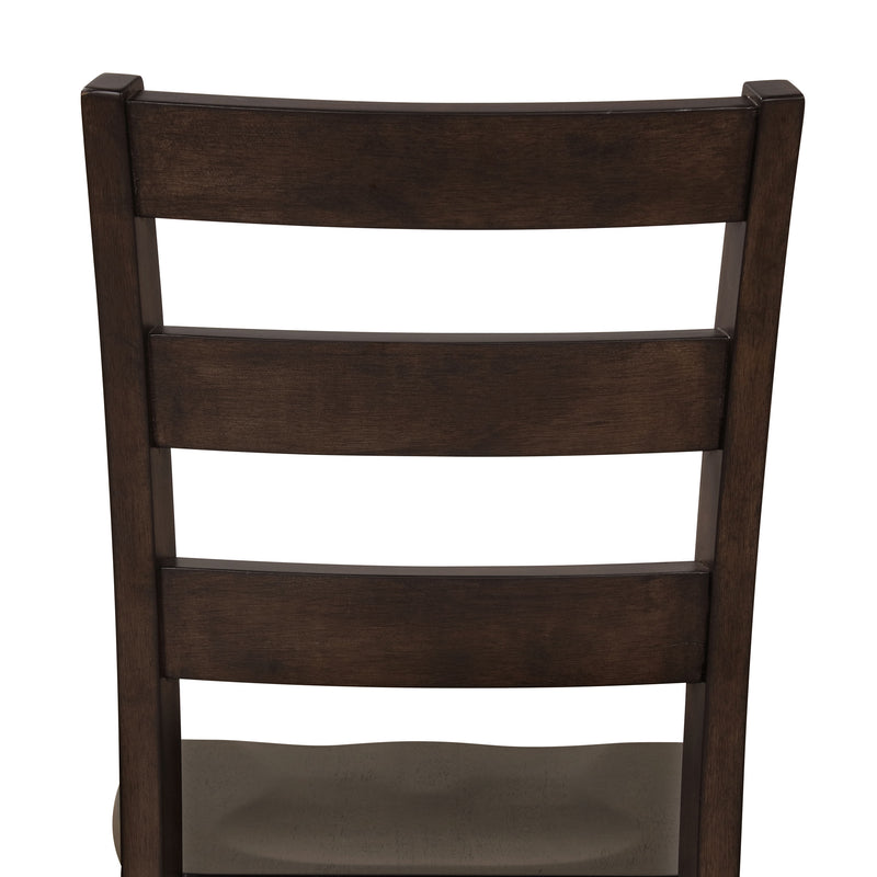 Front-facing close up of the ladder back of the side chair featured in a five-piece traditional espresso wooden dining set with a table and four chairs on a white background