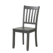 Left facing chair-only view of five-piece traditional grey wooden dining set with a table and four chairs on a white background