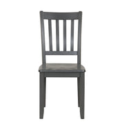 Front facing chair-only view of five-piece traditional grey wooden dining set with a table and four chairs on a white background