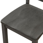 Left-facing close up of the contoured seat of the side chair featured in a five-piece traditional grey wooden dining set with a table and four chairs on a white background