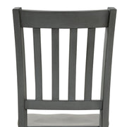 Front-facing close up of the slatted back of the side chair featured in a five-piece traditional grey wooden dining set with a table and four chairs on a white background