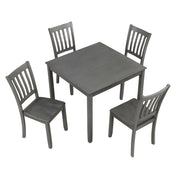 Side facing high-camera view of a five-piece traditional grey wooden dining set with a table and four chairs on a white background
