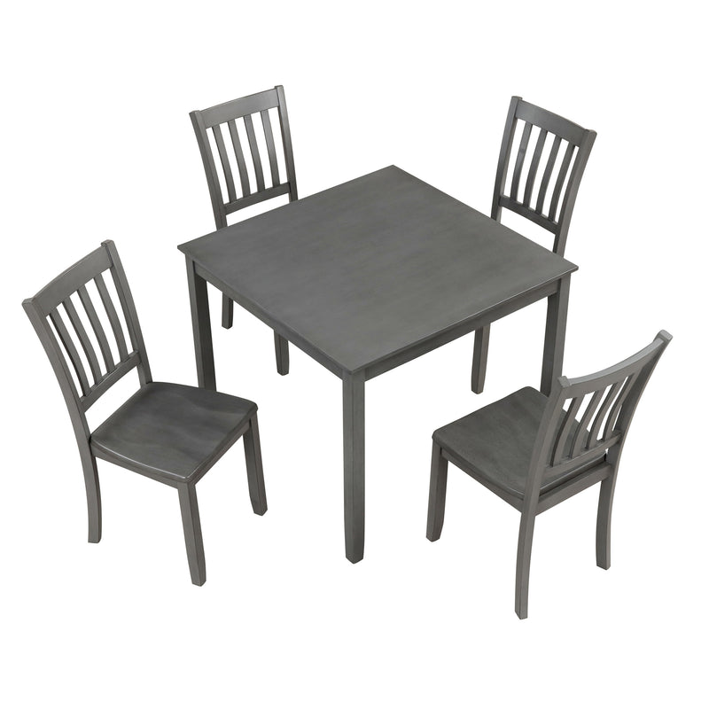Side facing high-camera view of a five-piece traditional grey wooden dining set with a table and four chairs on a white background