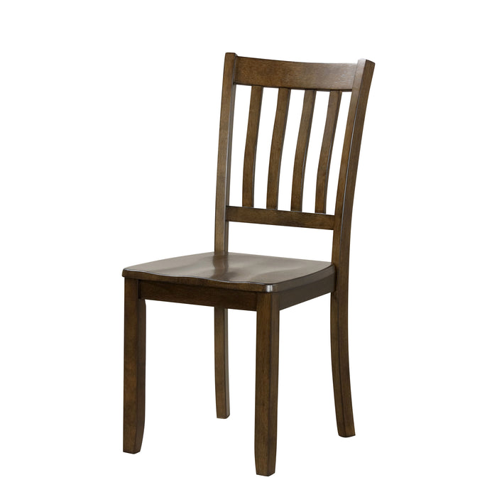 Left facing chair-only view of five-piece traditional walnut wooden dining set with a table and four chairs on a white background