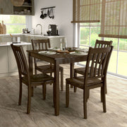Side facing five-piece traditional walnut wooden dining set with a table and four chairs in a room with accessories