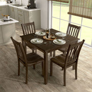 Side facing five-piece traditional walnut wooden dining set with a table and four chairs in a room with accessories