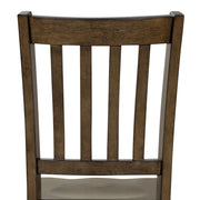 Front-facing close up of the slatted back of the side chair featured in a five-piece traditional walnut wooden dining set with a table and four chairs on a white background
