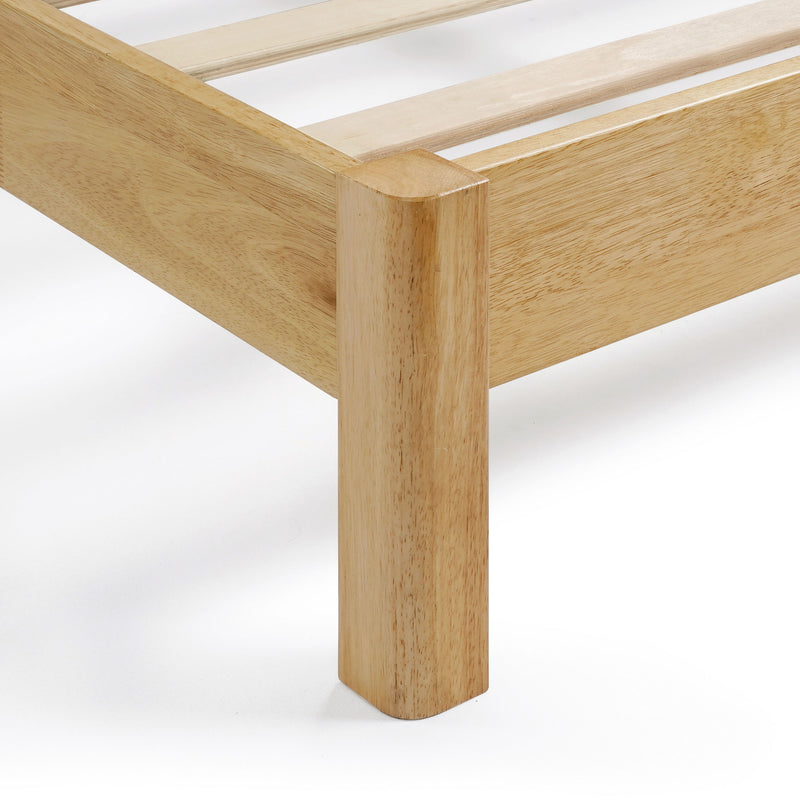 Right facing close up corner leg view of a modern wood frame queen platform bed with a channel tufted upholstered white boucle headboard on a white background