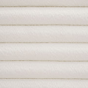 Front facing close up headboard view of a modern wood frame queen platform bed with a channel tufted upholstered white boucle headboard