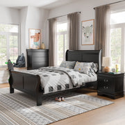 Left facing three-piece traditional black finish solid wood full bedroom set with (1) full sleigh bed, (1) two-drawer nightstand, and (1) five-drawer chest in a room with linens and accessories