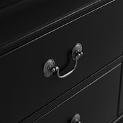 Right facing close up view of a traditional black finish solid wood two-drawer nightstand showing its antique hanging pulls, on a white background