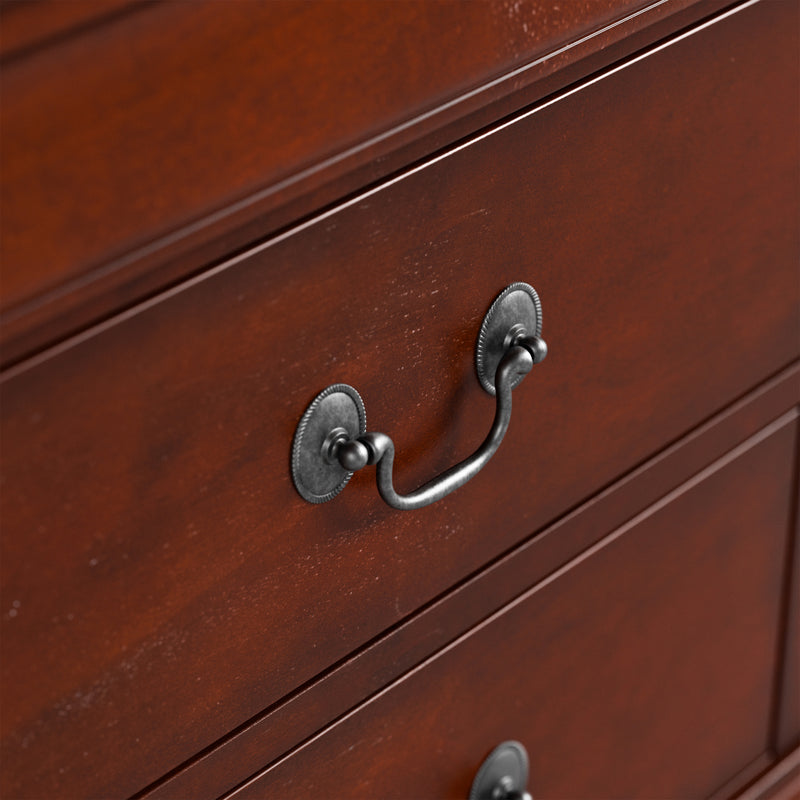 Right facing close up of a traditional cherry finish solid wood five-drawer chest showing its hanging drawer pulls