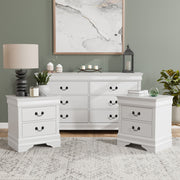 Three-piece traditional white finish bedroom set that includes (1) five-drawer chest and (2) two-drawer nightstands in a room with accessories