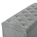 Right facing close up of a modern grey upholstered storage bench with a lift top on a white background