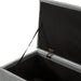 Left facing close up of the open top of a modern grey upholstered storage bench with a lift top in a room with accessories