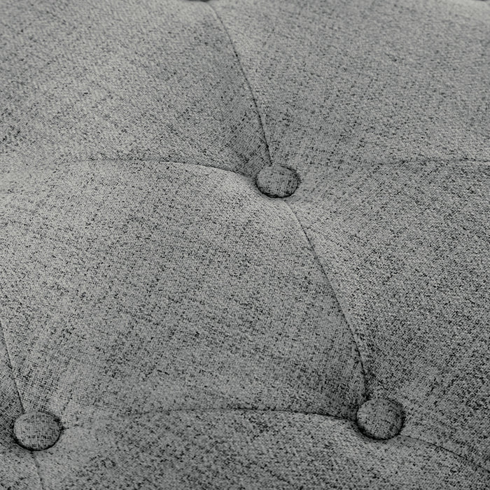 Close up of the button tufting of a modern grey upholstered storage bench with a lift top on a white background