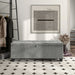 Front facing modern grey upholstered storage bench with a lift top in a room with accessories