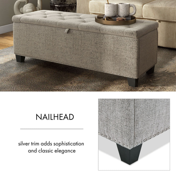 Informational image of the nailhead trim of a modern grey upholstered storage bench with a lift top