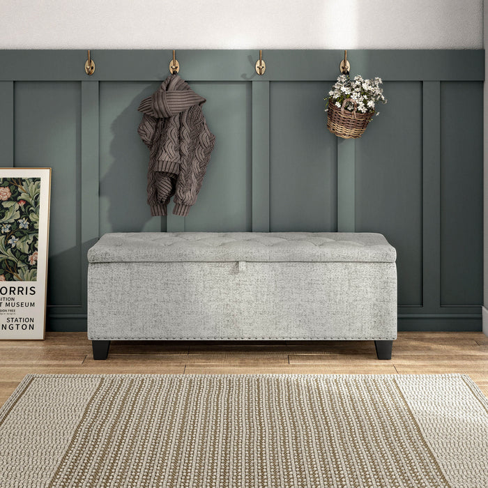 Front facing modern off white upholstered storage bench with a lift top in a room with accessories