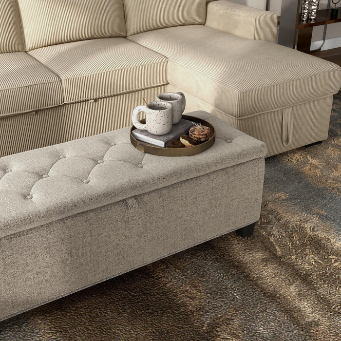 Right facing modern light brown upholstered storage bench with a lift top in a room with accessories