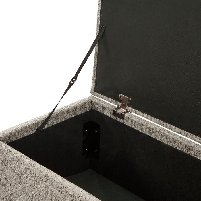 Left facing close up of the open top of a modern light brown upholstered storage bench with a lift top on a white background