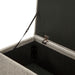 Left facing close up of the open top of a modern light brown upholstered storage bench with a lift top on a white background