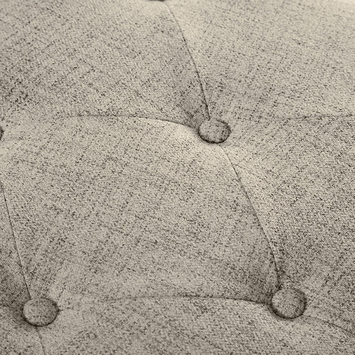 Close up of the button tufting of a modern light brown upholstered storage bench with a lift top on a white background