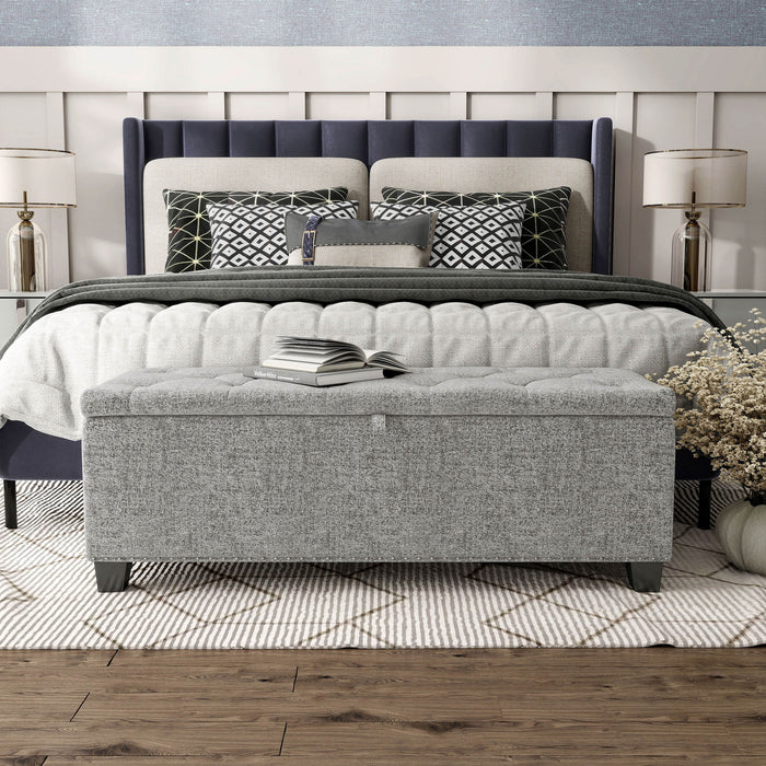 Front facing modern light grey upholstered storage bench with a lift top in a room with accessories