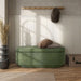 Front facing modern tufted green chenille oval storage bench in a room with accessories