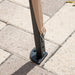 Close up view of the support leg of a modern beige portable camping gazebo canopy with roof and anchors on patio paver stones