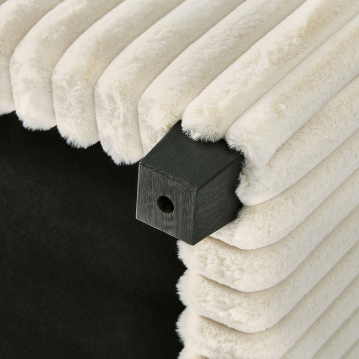 Left facing close up of the bottom of the leg a modern white chenille rectangular storage ottoman with two tray tops in a room with accessories