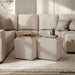 Left facing modern tufted beige pink chenille storage ottoman with a reversible tray top in a room with accessories