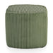 Front facing side view of a modern tufted green chenille round storage ottoman with a flip top on a white background