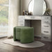 Left facing modern tufted green chenille round storage ottoman with a flip top in a room with accessories