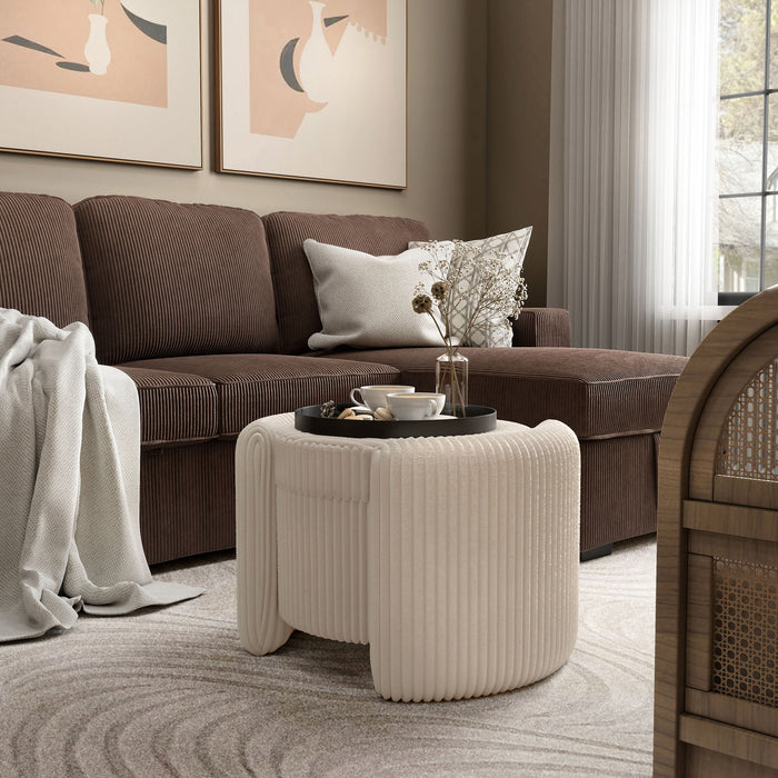 Left facing modern tufted beige pink chenille round storage ottoman with a flip top in a room with accessories