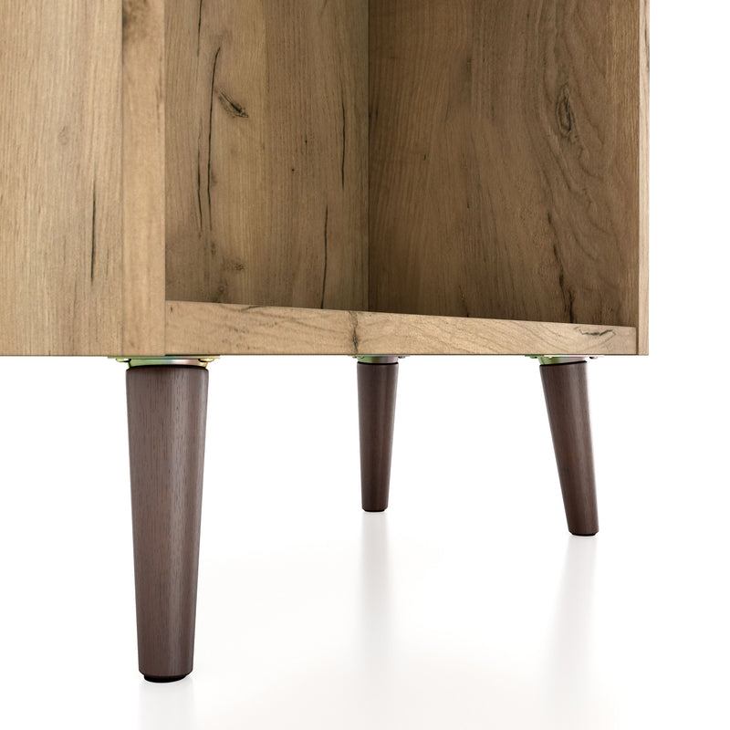 Right facing close up of the leg of a mid-century modern light oak two-drawer tall bookcase on a white background
