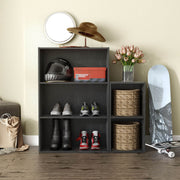 Front facing durable modern three-shelf black storage bookcase in a larger modular configuration in a room with accessories