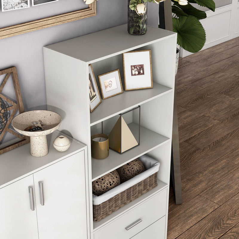 Right facing high camera view of a durable modern three-shelf white storage bookcase in a larger modular configuration in a room with accessories