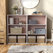 Front facing durable modern three-shelf light pink storage bookcase in a larger modular configuration in a room with accessories