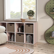 Right facing durable modern four-cubby light pink storage bookcase as part of a larger modular configuration in a room with accessories
