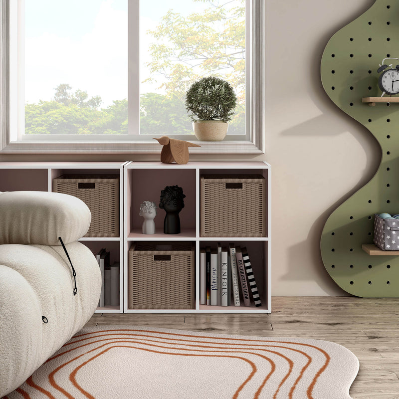 Front facing durable modern four-cubby light pink storage bookcase as part of a larger modular configuration in a room with accessories