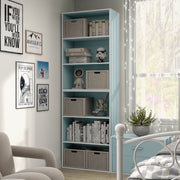 Left facing durable modern three-shelf light blue storage bookcase in a larger modular configuration in a room with accessories