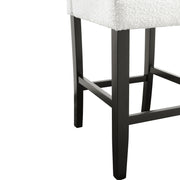 Right facing close up single view of a set of two contemporary black with white boucle counter height stools on a white background