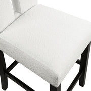 Right facing close up single view of a set of two contemporary black with white boucle counter height stools on a white background