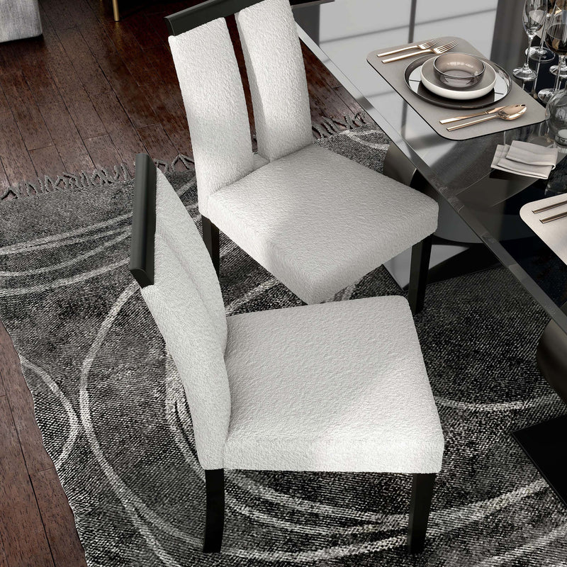 Right facing bird's eye single view of a set of two contemporary black with white boucle dining side chairs in a room with accessories